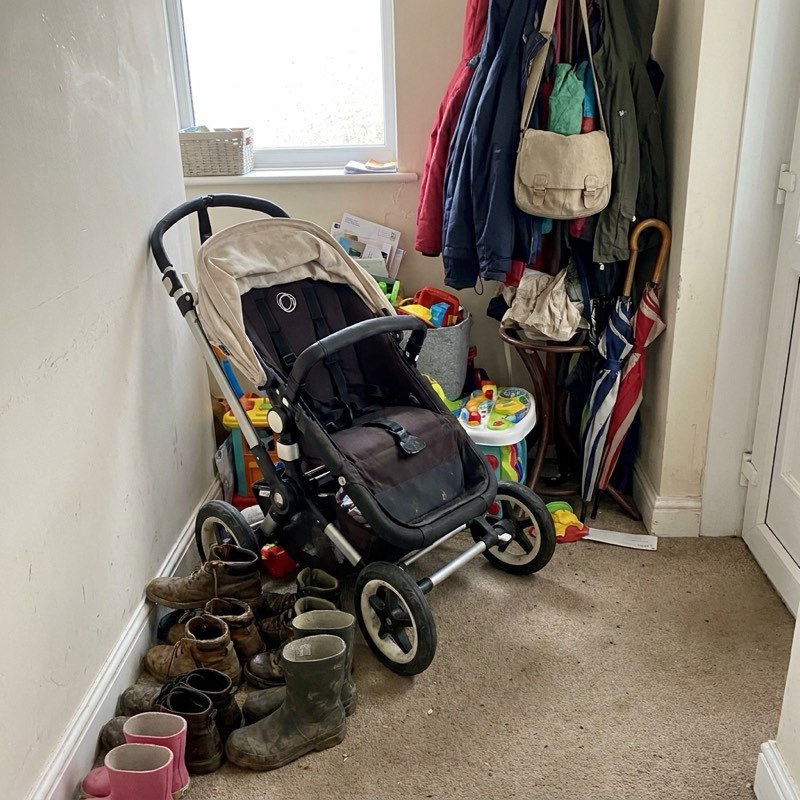 A folded child's pram in a hallway.